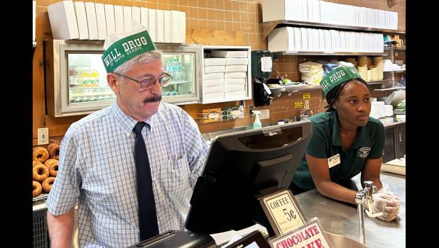 Rick Hustead, chairman of Wall Drug, works the restaurant counter when things get busy. Hustead, whose grandfather opened the store in 1931, says he’d never close the pharmacy, even though it’s not the main attraction. “We can’t be Wall Drug without being a drugstore,” he says. Courtesy Arielle Zionts/KFF Health News
