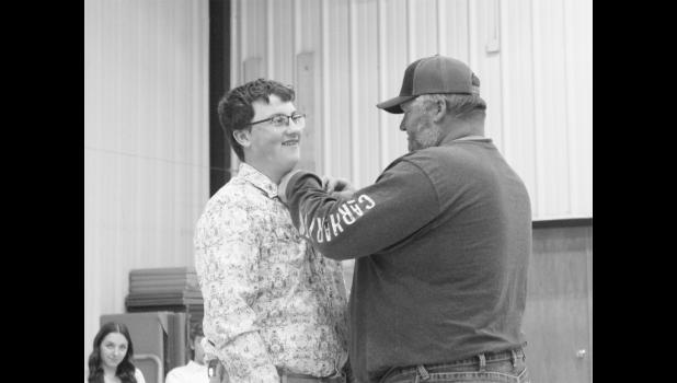 New NHS member Easton Newsam receives his pin from his father Levi Newsam in the pinning ceremony.