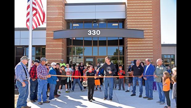 Shown above, many guests gathered to be part of the grand ribbon cutting to the new school building in Philip. After the official ceremony, people toured the new building and renovated original section. Students helped answer questions and show people around. Shown at right are, from left, Dilyn Terkildsen, Owen Terkildsen and John Piroutek, just a few of the students helping answer questions and show people around the new building during its open house. Deb Smith