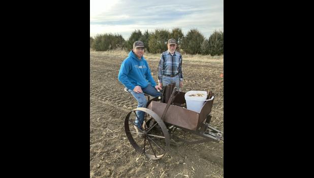 Milton Storm teaches Teigan Clark ... the fine art of planting potatoes. Teigan is riding on the club's International Harvestor potato planter. Courtesy photo by Wade Hofer